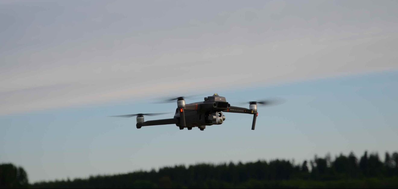 Eine mit Kamera ausgestattete Drohne schwebt über einer Landschaft