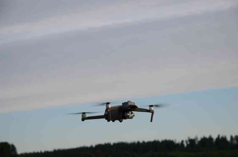 Eine mit Kamera ausgestattete Drohne schwebt über einer Landschaft