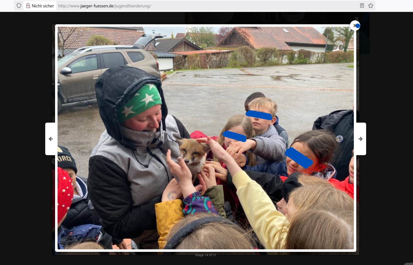 Ein Screenshot von www.jaeger-fuessen.de zeigt ein Foto einer Person, die Kindern einen Fuchs zum Streicheln hin hält