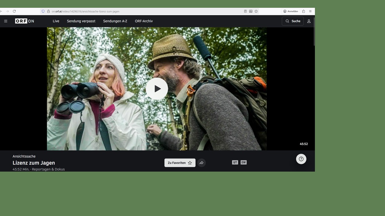 Vor grünem Hintergrund ein Screenshot eines Videos, wo eine Frau mit Fernglas neben einem Mann in Jagdkleidung steht