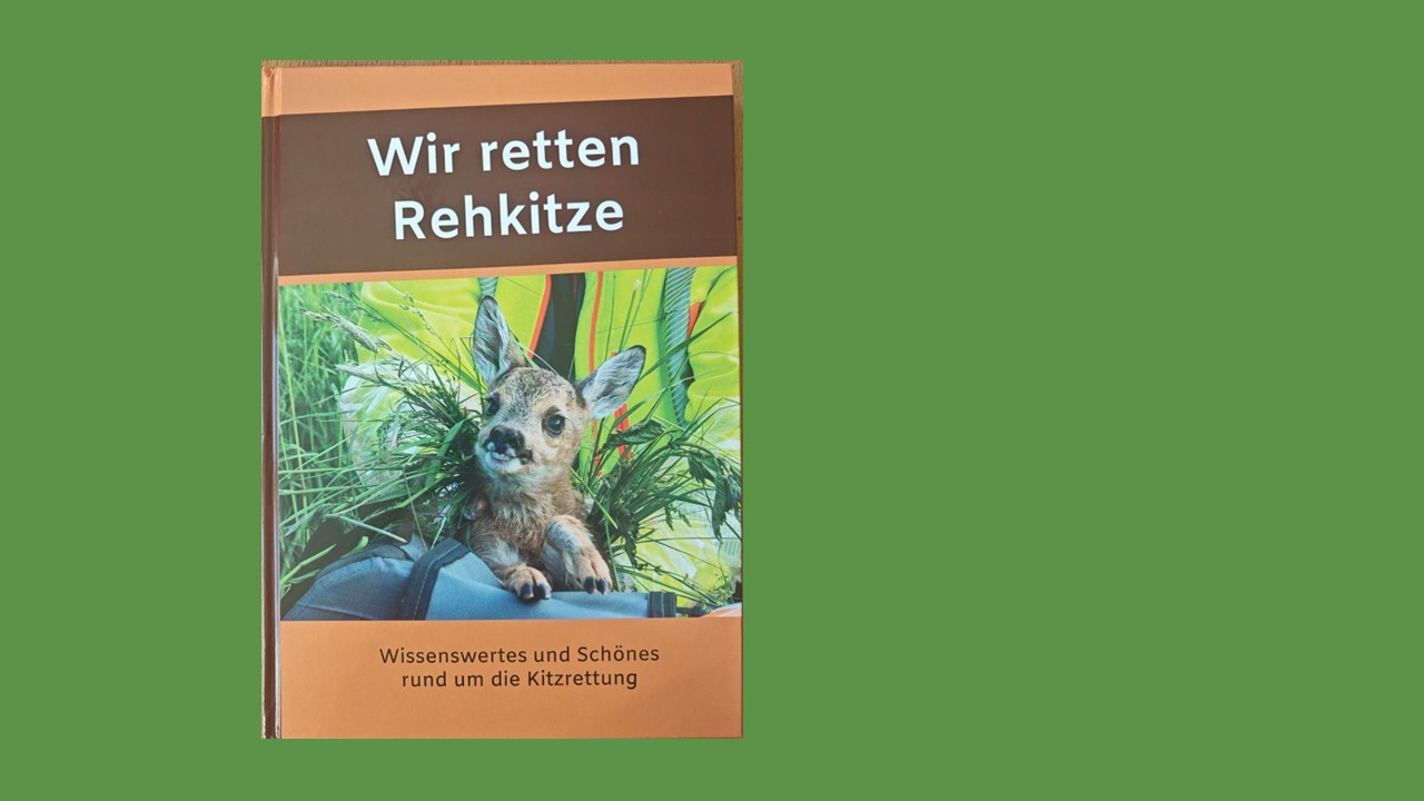 Vor grünem Hintergrund ein braunes Buch mit einem Rehkitz auf dem Cover und dem Titel "Wir retten Rehkitze"