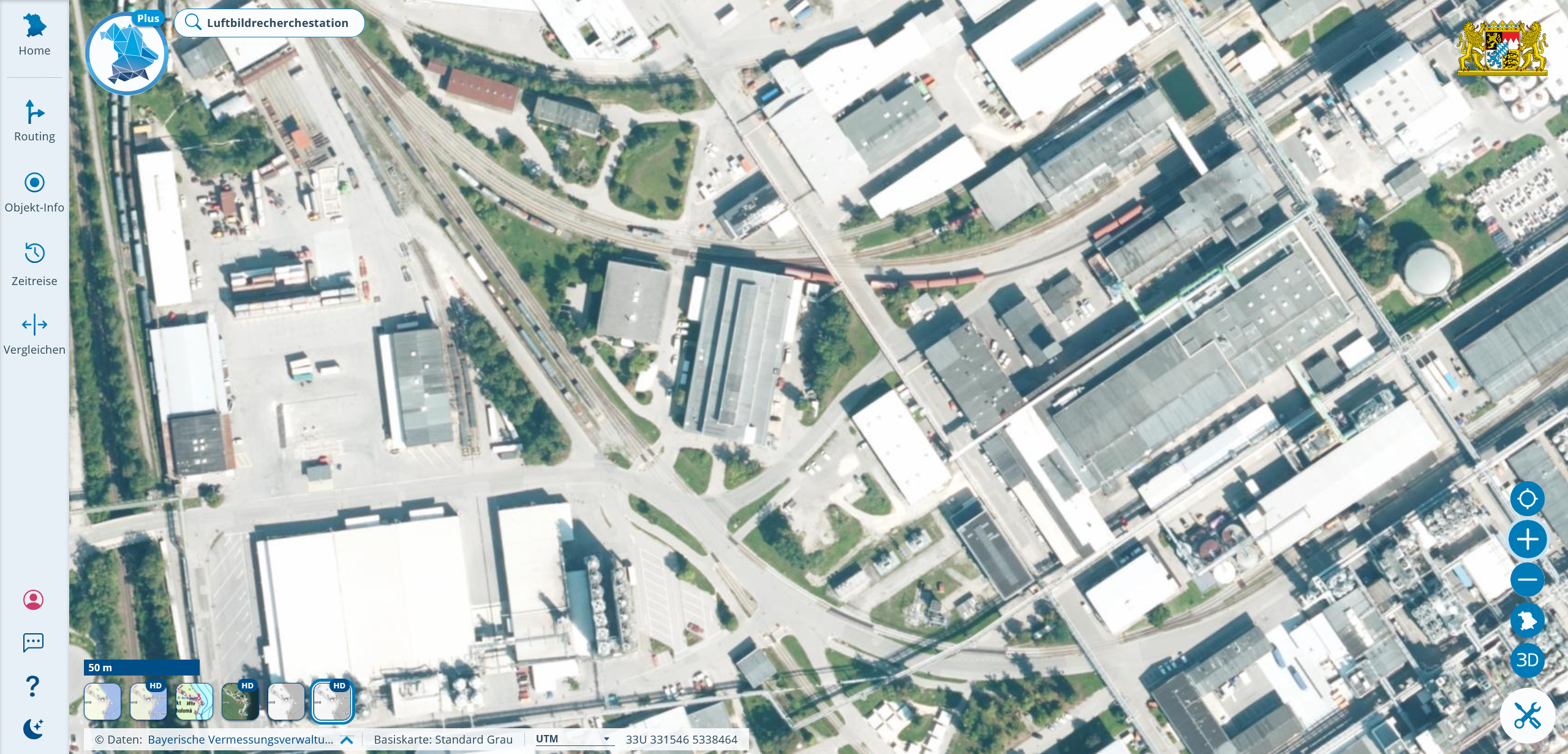 Auszug aus dem Luftbild eines Industriegebiets, man erkennt Straßen, Bahngleise und die weißen und dunkelgrauen Dächer großer Hallen und Gebäude,
